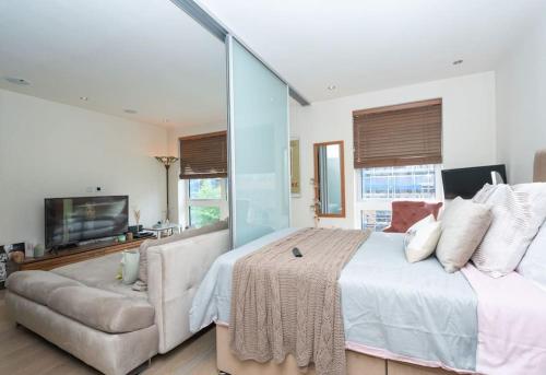 a bedroom with a large bed and a couch at Charming Manhatten studio Apartment Chelsea in London