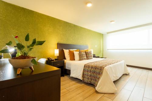 a hotel room with a bed and a table at Hotel Carretero in Manizales