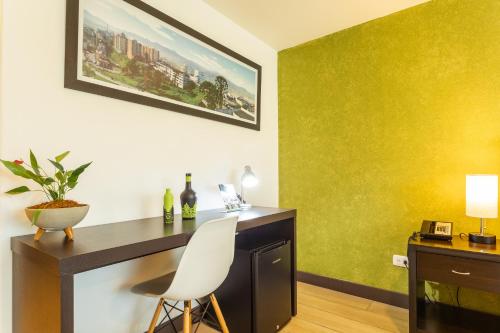 a desk with a white chair in a room at Hotel Carretero in Manizales