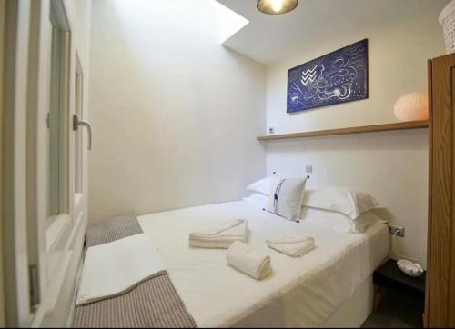 a bedroom with a white bed with two pillows on it at NESEA Boutique Apartments in Hydra