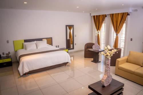 a bedroom with a large bed and a couch and a table at Hotel SanJo in San José Iturbide