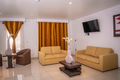 a living room with two chairs and a vase with flowers at Hotel SanJo in San José Iturbide