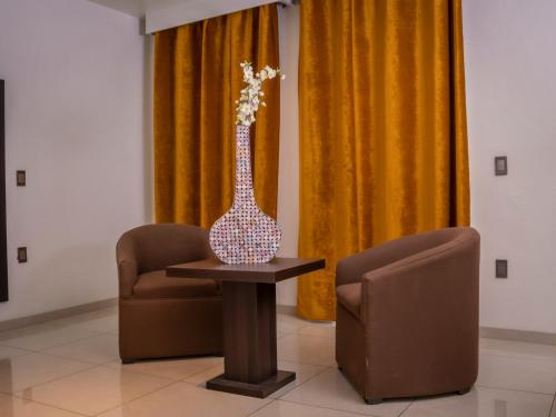 a vase sitting on a table next to two chairs at Hotel SanJo in San José Iturbide