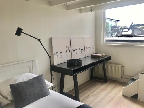 a room with a desk with paintings on the wall at Quiet Waterloft near Amsterdam and Schiphol WS17 in Aalsmeer