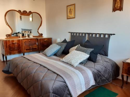 a bedroom with a bed with pillows and a mirror at Giaveno, apartment "margherita" a pochi passi dal centro, wifi in Giaveno