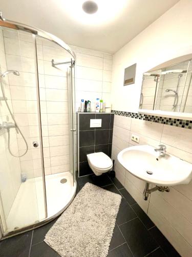 a bathroom with a shower and a sink and a toilet at Pension Maier in Villach