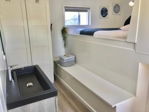 a bathroom with a sink and a bed in a room at Quiet Waterloft near Amsterdam and Schiphol WS17 in Aalsmeer