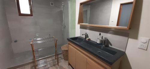 une salle de bain avec un lavabo noir et un miroir dans l'établissement SAKURA, Paisible et confortable appartement à la campagne, à Monteux