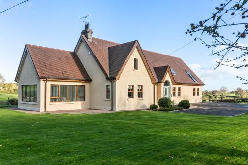 a house with a green lawn at Tollyrose Country House in Newcastle