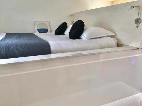 a bed with two pillows sitting on a shelf at Quiet Waterloft near Amsterdam and Schiphol WS17 in Aalsmeer