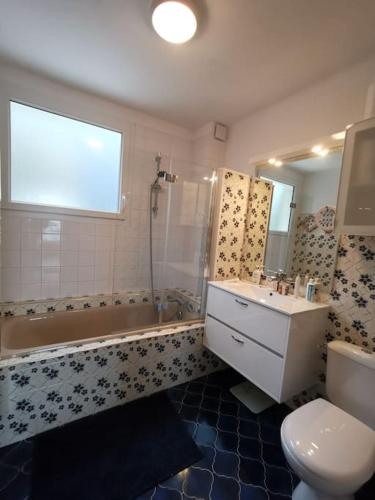 une salle de bain avec un lavabo, une baignoire et des toilettes dans l'établissement Charme et zénitude, avec vue exceptionnelle sur le port, à Granville