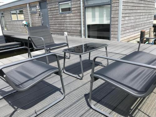 a group of chairs and a table on a deck at Quiet Waterloft near Amsterdam and Schiphol WS17 in Aalsmeer