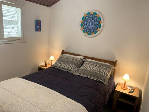 a bedroom with a bed with two night stands and two lamps at Chalé da Araucária in Campos do Jordão