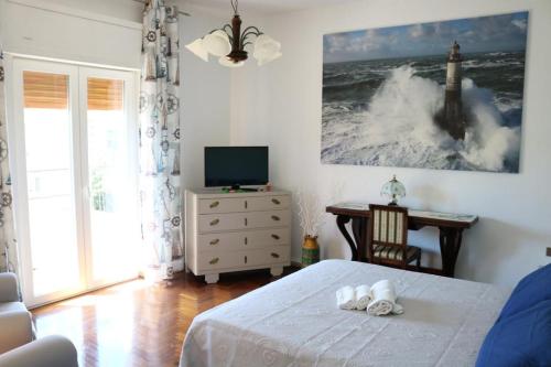 a bedroom with a bed and a television and a table at ROSSINI APARTMENT FRONTE MARE in Follonica