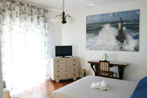 a bedroom with a bed and a tv and waves at ROSSINI APARTMENT FRONTE MARE in Follonica