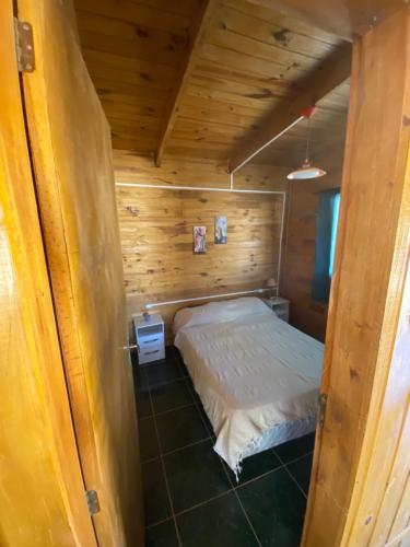 Habitación pequeña con 1 cama en una cabaña de madera en Tadekim, en Punta del Diablo