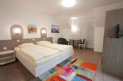 1 dormitorio con 1 cama y 1 mesa con TV en Hotel Lingemann, en Wallenhorst