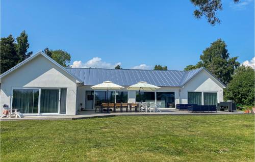 a white house with tables and umbrellas at Cozy Home In Skivarp With Wifi in Skivarp