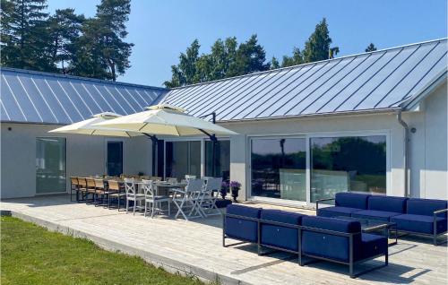 a patio with a table and chairs and an umbrella at Cozy Home In Skivarp With Wifi in Skivarp