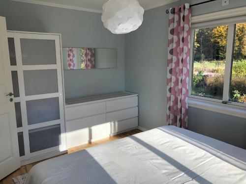 1 dormitorio con cama y ventana en Ferienhaus mit Garten und Holzterrasse direkt am See 