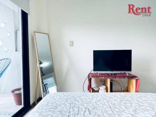 1 dormitorio con 1 cama y mesa con TV en Rent Corrientes y Lambaré en Buenos Aires