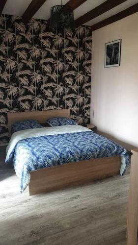 um quarto com uma cama com um edredão azul em Maison de village au bord de l'Indre au calme em Avoine