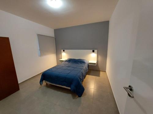 1 dormitorio con 1 cama con manta azul en BRADAS San Juan en San Juan