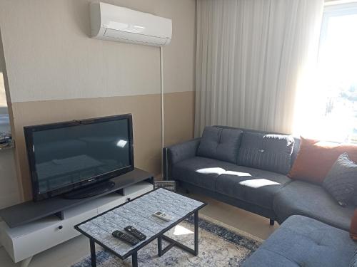 ein Wohnzimmer mit einem Sofa und einem Flachbild-TV in der Unterkunft ManavgatApartment in Manavgat