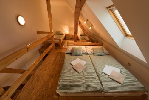 an attic room with two beds and a staircase at Penzion Adršpach " U Kozárů " in Teplice nad Metují