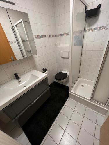 a white bathroom with a sink and a toilet at Ferienwohnung Mousse au Chocolat in Korbach