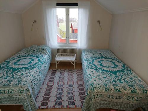 2 Betten in einem kleinen Zimmer mit Fenster in der Unterkunft Vesteby Hus - a peaceful stay in the countryside! in Grästorp