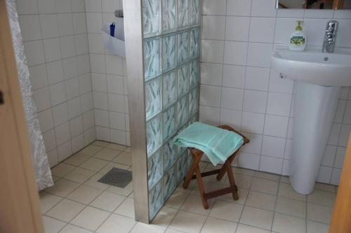 ein Bad mit einer Dusche, einem Waschbecken und einem Stuhl in der Unterkunft Vesteby Hus - a peaceful stay in the countryside! in Grästorp