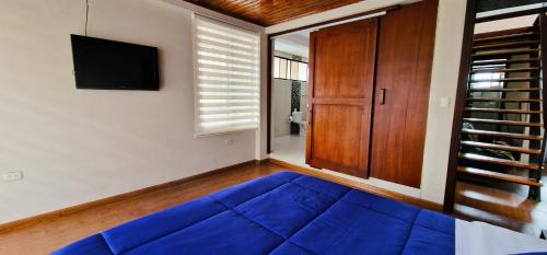 ein Wohnzimmer mit einem blauen Sofa und einem Fernseher in der Unterkunft TU CASA EN MACAS in Macas