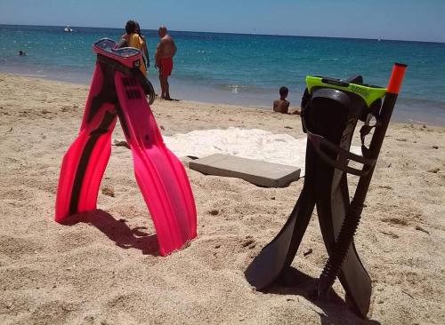 twee speeltoestellen in het zand op het strand bij Trilocale Margine Rosso in Quartu SantʼElena