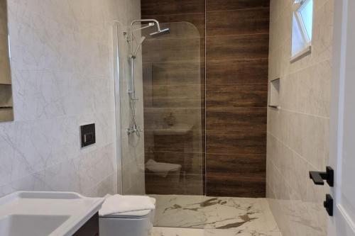 een badkamer met een douche, een toilet en een wastafel bij Dalyan Villa White Cloud in Dalyan