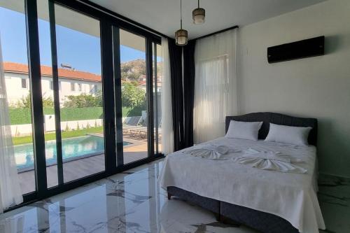 een slaapkamer met een bed en uitzicht op een zwembad bij Dalyan Villa White Cloud in Dalyan