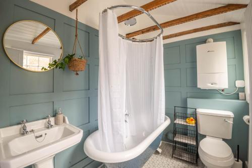 a bathroom with a white tub and a sink at The Broadstairs Townhouse in Broadstairs