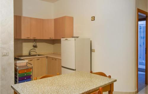 a kitchen with a refrigerator and a table with chairs at Lovely Apartment In Marina Di Strongoli With House Sea View in Marina di Strongoli