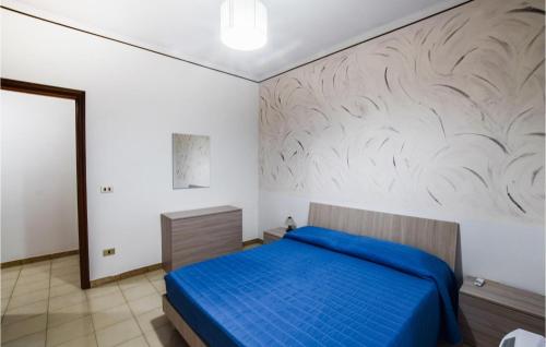 a bedroom with a blue bed and a white wall at Lovely Apartment In Marina Di Strongoli With House Sea View in Marina di Strongoli