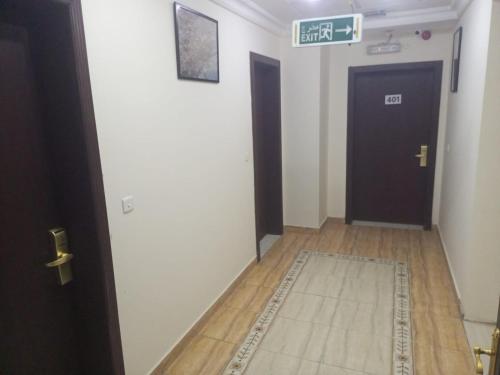 a hallway with a door and a sign that reads exit at VIP For Apartment - شقق فاخره in Al ‘Awālī