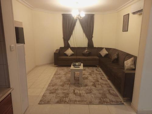 a living room with a couch and a table at VIP For Apartment - شقق فاخره in Al ‘Awālī