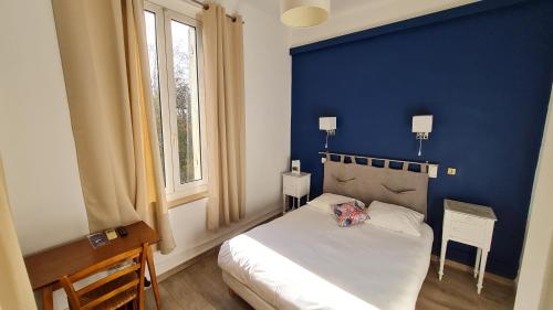 Un dormitorio con una pared azul y una cama en Constantin en Arlés