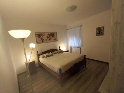 Un dormitorio con una cama y una lámpara. en appartamento la pineta 10058-LT-0004, en Serra Rocco