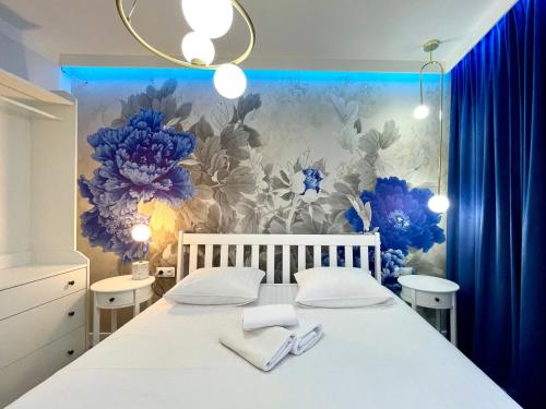 1 dormitorio con 1 cama con flores azules en la pared en BelleView Apartment, en Toruń