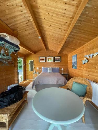 a bedroom with a bed and a table and chairs at The Log Cabin in Wimborne Minster