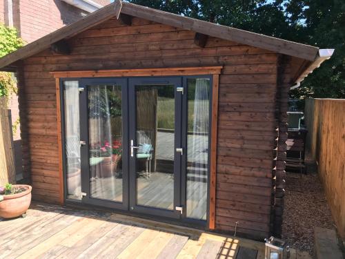 a garden room with sliding glass doors on a deck at The Log Cabin in Wimborne Minster