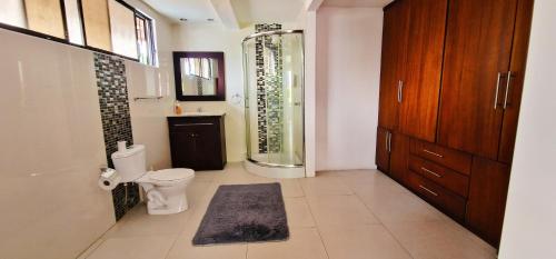 a bathroom with a toilet and a glass shower at TU CASA EN MACAS in Macas