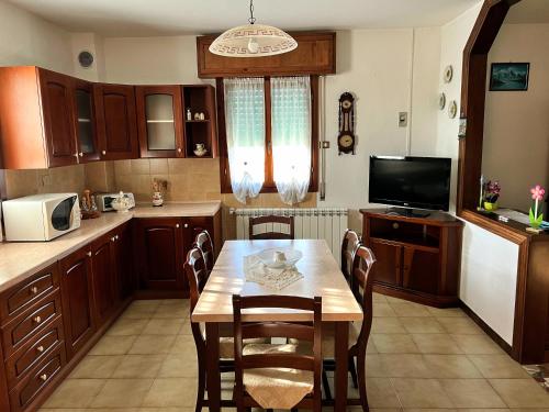 a kitchen with a table with chairs and a television at CASA GIULIETTA in Tolle