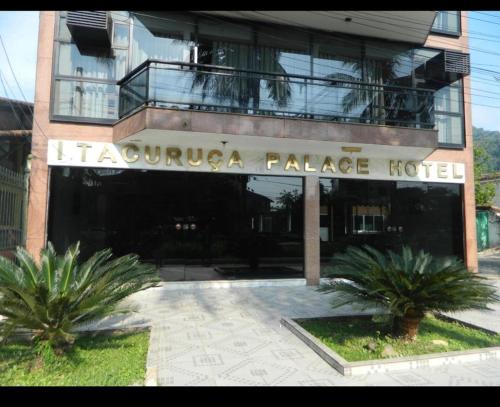 a building with a sign that reads iguana palace hotel at Itacuruça Palace Hotel in Mangaratiba