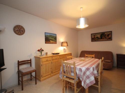 une salle à manger avec une table et un canapé dans l'établissement Charmant T2 avec balcon exposé Ouest, parking privé, au Mont-Dore, proche centre et Thermes - FR-1-608-190, à Le Mont-Dore